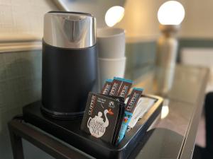 a table with a coffee maker and books on it at Wedgwood Hotel, North Shore Room in Llandudno
