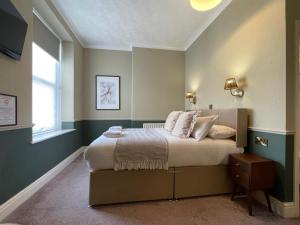 a bedroom with a bed and a window at Wedgwood Hotel, North Shore Room in Llandudno