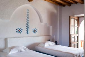 Dos camas en una habitación con paredes blancas. en Chic 6 Bedroom Villa in Ibiza City, 1259, en Portinatx 26 fotos más