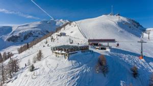 a snow covered mountain with a ski lodge on it at Campingplatz Mauterndorf in Mauterndorf +12 photos