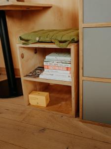 a book shelf with a stack of books at Hoku in Llangollen
