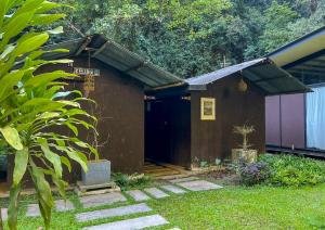 a small building with a black door in a yard at Xscape Tambun - Cabin in the Valley in Tambun +2 photos