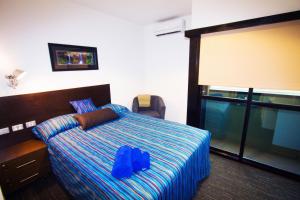 ein Hotelzimmer mit einem Bett mit blauem Rucksack in der Unterkunft The Landing Port Hedland in Port Hedland