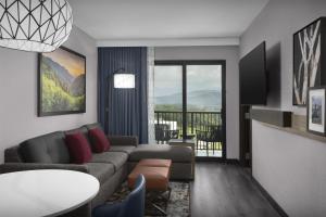 鸽子谷Embassy Suites By Hilton Pigeon Forge Resort的带沙发和桌子的客厅