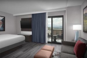 鸽子谷Embassy Suites By Hilton Pigeon Forge Resort的带床和阳台的酒店房间