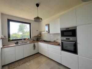 a kitchen with white cabinets and a window at Dimora dei Climiti in Floridia