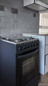 a black stove top oven in a kitchen at Siphosami Apartments - Unit 2 Mopane in Lilongwe