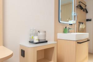 a bathroom with a sink and a mirror at Hi Inn Beijing Wufutang Subway Station Zhongke E-commerce Valley in Beijing +15 photos