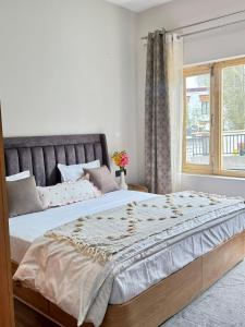 une chambre avec un grand lit avec une fenêtre dans l'établissement TSAO by the orchard-Boutique Stay, à Leh