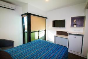 mały pokój z łóżkiem i telewizorem w obiekcie The Landing Port Hedland w mieście Port Hedland