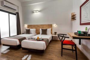 a hotel room with two beds and a desk at Collection O Thrissur Zoo & Museum in Trichūr