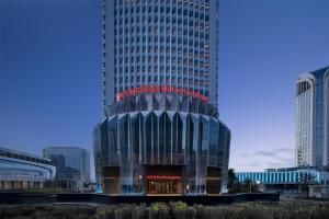 ウルムチ市にあるHilton Garden Inn Urumqi Railway Stationの上に看板がある高い建物