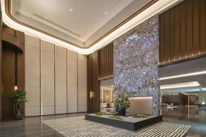 a lobby of a hotel with a large glass wall at Hilton Garden Inn Urumqi Railway Station in Ürümqi