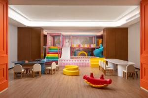 una sala de juegos para niños con mesa y sillas en La Quinta by Wyndham Suzhou Yangshan, en Suzhou