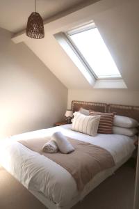 a bedroom with a large white bed with a skylight at Apartments in the centre of Donaghadee in Donaghadee