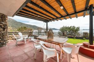 ヴィッラシミーウスにあるWaterside Oasis Houseのパティオ(木製テーブル、白い椅子付)