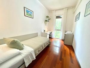 Una habitación blanca con un sofá y una ventana. en A casa di cocco, en Padua