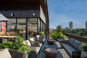 un patio avec des chaises et des tables sur un bâtiment dans l'établissement Hotel Nucha-Fattal Colors, à Jérusalem