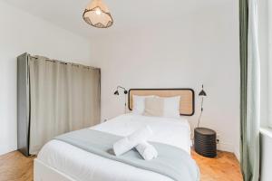 a bedroom with a white bed with two towels on it at La Madeleine -two bedroom apartment in La Madeleine +6 photos