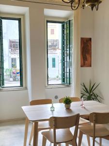 una sala da pranzo con tavolo, sedie e finestre di Testaccio Charme Apt a Roma