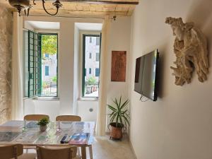 una sala da pranzo con un tavolo e una TV a parete di Testaccio Charme Apt a Roma