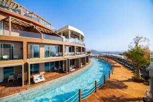 a hotel with a swimming pool next to a building at Qlusive Hotel in Kuşadası