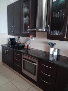 a kitchen with wooden cabinets and a stove top oven at Blythedale Splendour in KwaDukuza