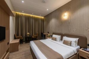a hotel room with a bed and a dining room at Hotel Kingsway Continental , Raipur in Raipur