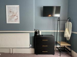 a room with a black dresser and a chair at Wedgwood Hotel - Room 4 in Llandudno