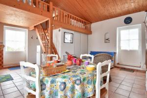 a dining room with a table and a wooden ceiling at 300m plage - Petite maison avec jardin pour 3 in LʼÉpine