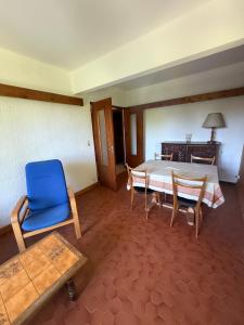 a room with a bed and a blue chair and a table at Choucas in Thollon +6 photos