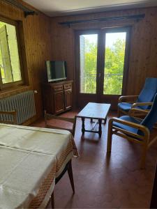 a room with two beds and a table and a tv at Choucas in Thollon