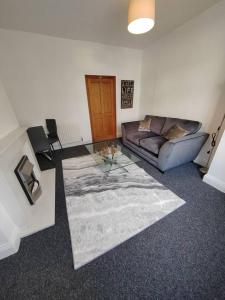 a living room with a couch and a glass table at Church View house,2bed,brighouse central location in Brighouse