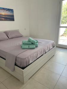 two green towels sitting on a bed in a room at Da Franco in Santa Luria