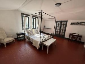 a bedroom with a canopy bed and a chair at Maison des Ingénieurs in Molières-sur-Cèze