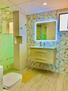 ein Badezimmer mit Toilette, Waschbecken und Spiegel in der Unterkunft Apto LUXURY BONAIRE in Puerto de Gandía