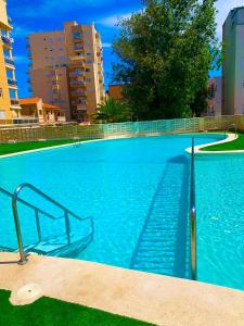 ein blauer Pool mit einer Metallhand in der Unterkunft Apto LUXURY BONAIRE in Puerto de Gandía