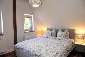 a bedroom with a white bed with pillows at Willa Muszelka - Apartamenty in Świnoujście