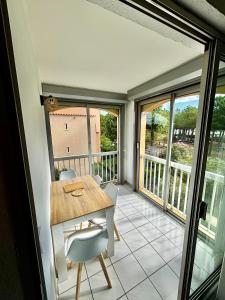 a dining room with a table and chairs on a balcony at Appartement avec loggia et mezzanine, bord de mer, 4 personnes in Argelès-sur-Mer +2 photos