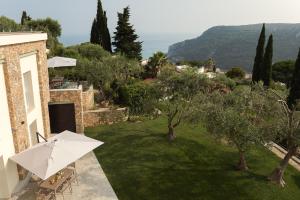 a garden with a table and an umbrella at Villa Serena in Finale Ligure