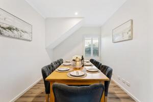 Un comedor con mesa y sillas de madera. en The Dromana Beach House - Stunning Views, en Dromana