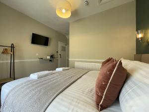 a bedroom with a bed with pillows on it at Wedgwood Hotel, Seascape Room in Llandudno