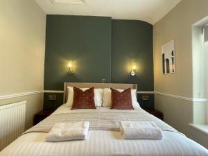 a bedroom with a large bed with two pillows at Wedgwood Hotel, Seascape Room in Llandudno