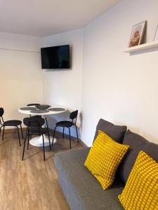 a living room with a couch and a table at Modernes Apartment im Zentrum inklusive Parkplatz in Osnabrück