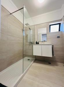 a bathroom with a glass shower and a sink at Apartamento Brisa Vicentina- Odeceixe in Odeceixe +17 photos