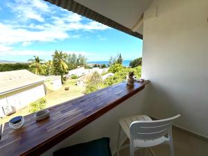 a balcony with a view of the ocean from a house at T2 duplex- piscine- vue mer in Saint-Paul