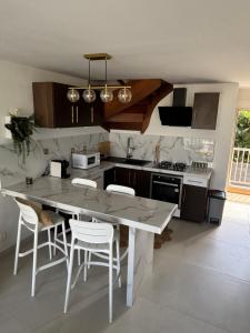 Saint-PaulにあるT2 duplex- piscine- vue merのキッチン(大きな白いテーブルと椅子付)