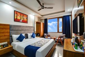 a hotel room with a bed and a desk and a room at Airport Le Premier, New Delhi in New Delhi