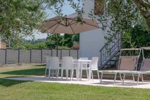 a table and chairs and an umbrella in a yard at Villa Marilyn - private garden pool and Jacuzzi in Bardolino