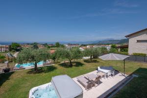 a view of a backyard with a hot tub and chairs at Villa Marilyn - private garden pool and Jacuzzi in Bardolino +41 photos